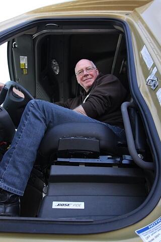 Truck driver sitting on bose ride system seat