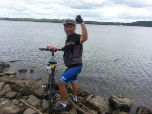 Man on bike beside a lake
