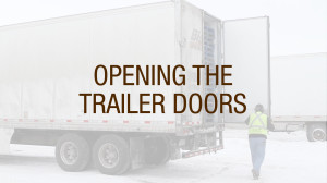 A truck driver opening trailer doors