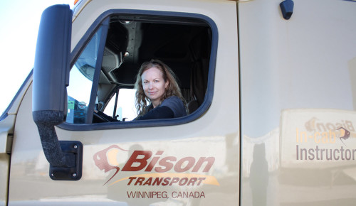 Female truck driver looking out window of truck