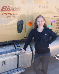Female truck driver standing beside truck